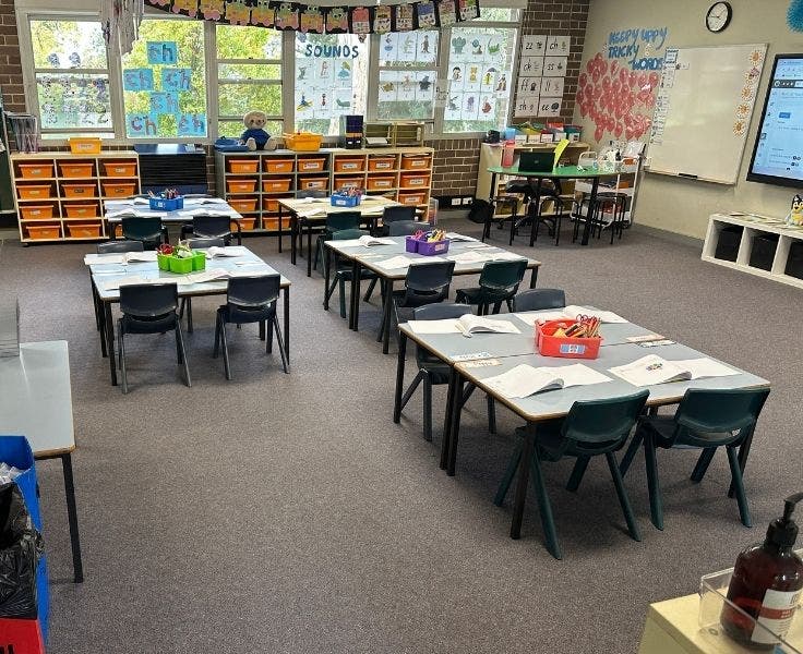 Picture of a classroom with desks and chairs arranged in groups
