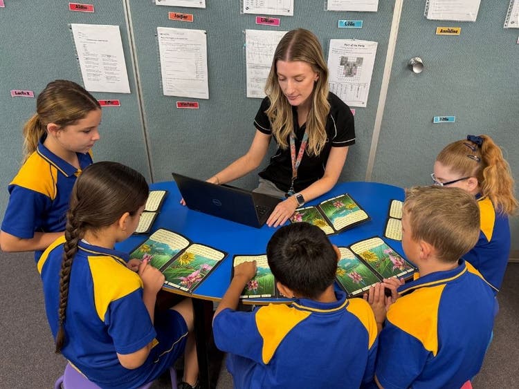 Teaher leading a reading group with five students