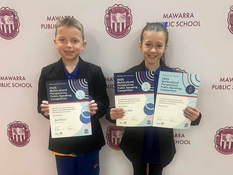 Picture of two students holding their public speaking awards